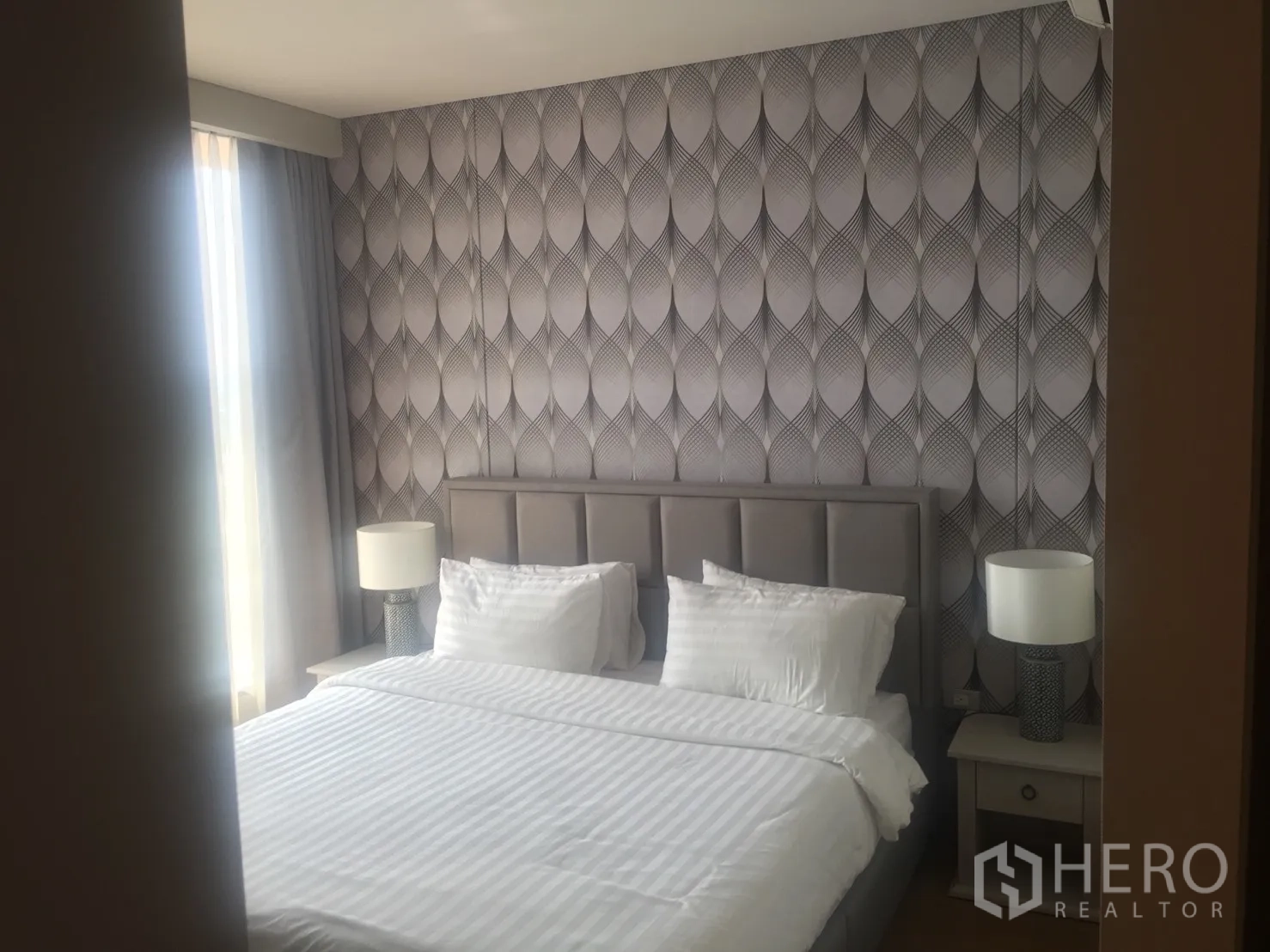 คอนโด ให้เช่าในKhlong Toei, Bangkok - ห้องนอนอบอุ่นด้วยวอลเปเปอร์ลายกราฟิก เตียงขนาดใหญ่และโคมไฟหัวเตียง