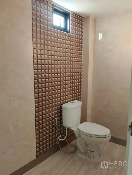 工厂 出租或出售在Sai Noi, Nonthaburi - 卫生间带古铜色纹理墙、通风小窗和坐便器。