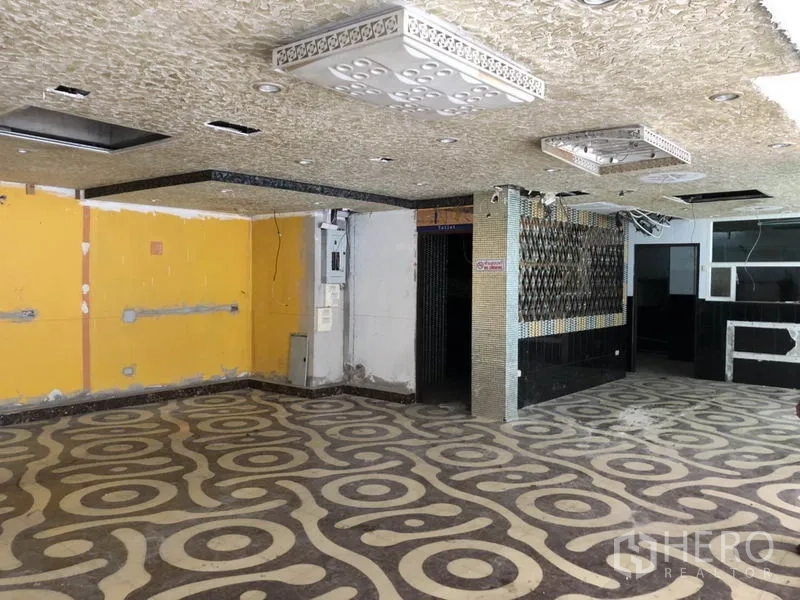 零售空间 出租在Khlong Toei, Bangkok - 开放式店内空间，几何图案地面与吊顶，待装修。