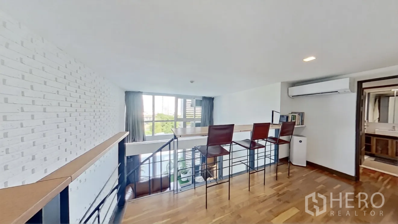 คอนโด for rent in Watthana, Bangkok - พื้นที่ชั้นลอยผนังอิฐทาสีขาวพร้อมที่นั่งบาร์และหน้าต่างบานใหญ่