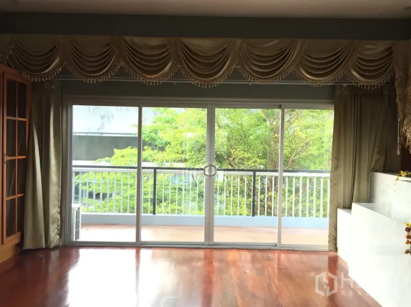 สำนักงานที่บ้าน ให้เช่าหรือขายในSuan Luang, Bangkok - ห้องนั่งเล่นพื้นไม้ เปิดสู่เทอเรซและต้นไม้ผ่านประตูกระจกบานเลื่อน