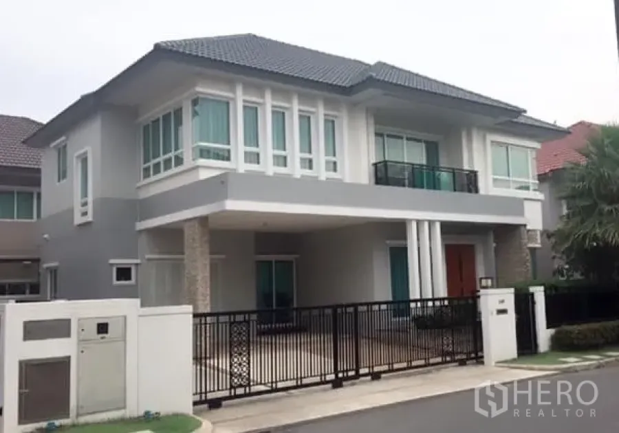 Detached House for rent or sale in Saphan Sung, Bangkok - Modern two-storey detached house with gated driveway and balcony in a secure estate.