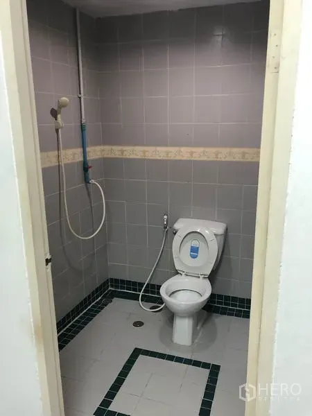 สำนักงาน ให้เช่าในRatchathewi, Bangkok - ห้องน้ำขนาดกะทัดรัด ปูกระเบื้องสีเทา มีโถสุขภัณฑ์ ฝักบัว และท่อระบายน้ำ
