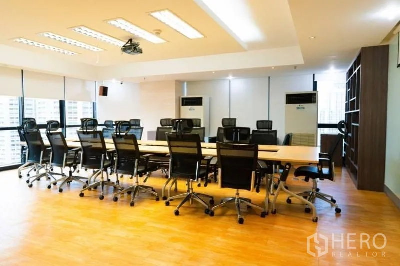 办公空间 出租在Khlong Toei, Bangkok - 宽敞会议室，董事会议桌、临窗采光与内置书架。