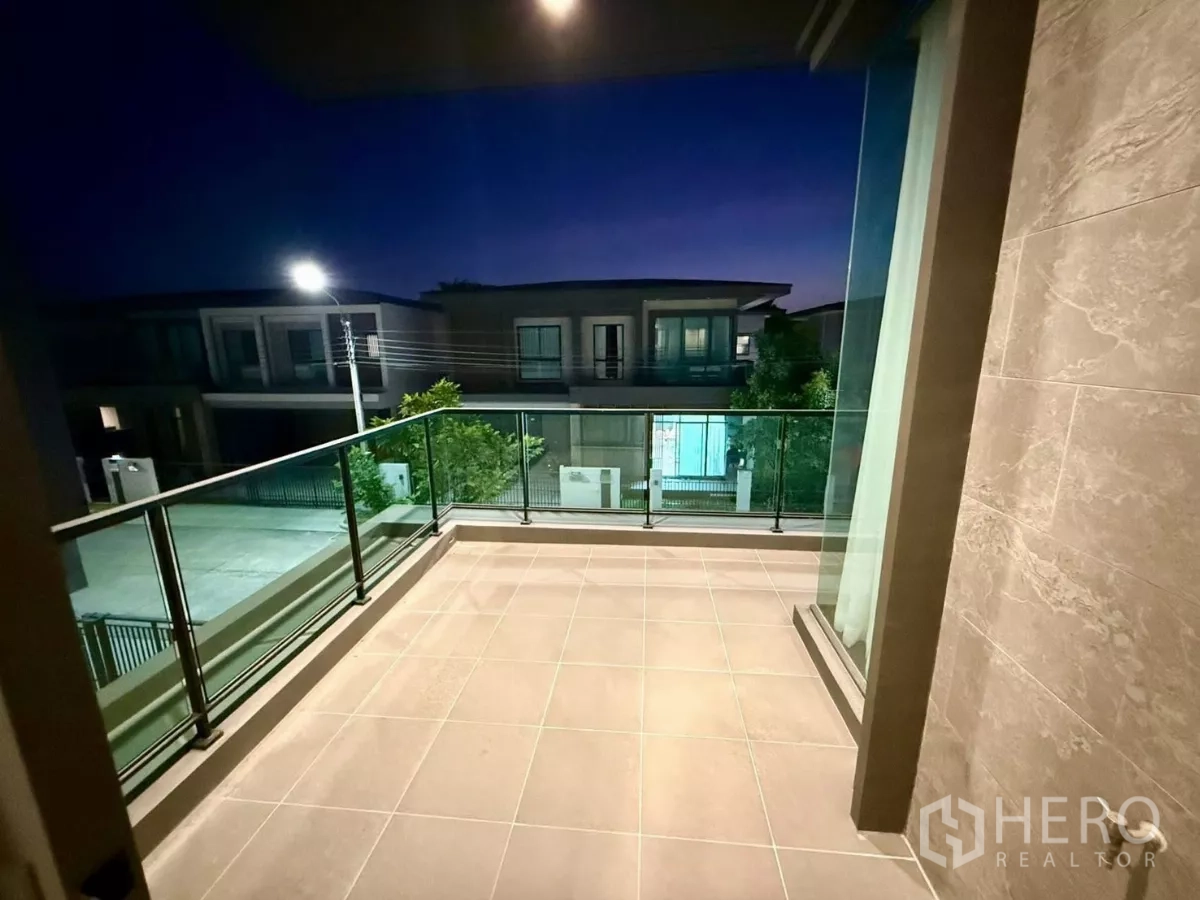 Detached House for rent in Bang Phli, Samut Prakan - Upper-floor balcony with glass railing overlooking a quiet residential street.