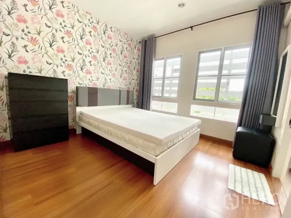 ทาวน์เฮาส์ ให้เช่าในPrawet, Bangkok - ห้องนอนรองสว่าง ผนังลายดอก เตียง ตู้ลิ้นชัก และหน้าต่างคู่