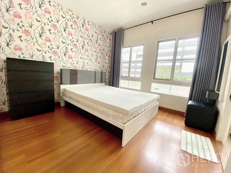 ทาวน์เฮาส์ ให้เช่าในPrawet, Bangkok - ห้องนอนรองสว่าง ผนังลายดอก เตียง ตู้ลิ้นชัก และหน้าต่างคู่