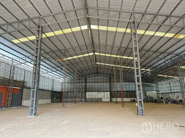 Warehouse for sale in Nong Chok, Bangkok - High-span warehouse bay with ventilation louvers and multiple steel pillars across the open floor.