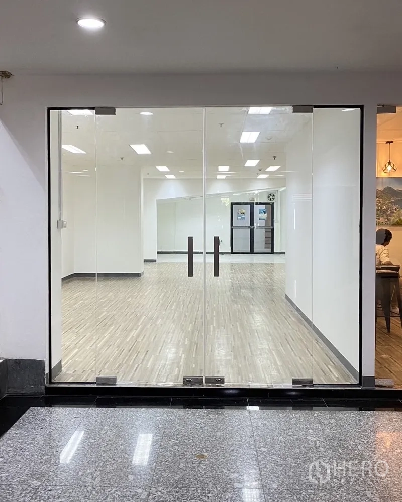 零售空间 for rent in Khlong Toei, Bangkok - 近距离展示双扇玻璃门，通向明亮的空置店铺。