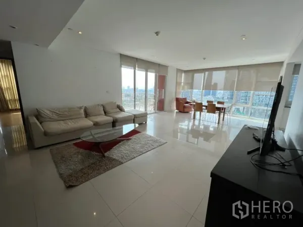 คอนโด ให้เช่าในWatthana, Bangkok - พื้นที่นั่งเล่นแบบเปิดกว้าง โซฟาเข้ามุม พื้นกระเบื้องเงา และหน้าต่างสูงจรดเพดานมองเห็นวิวเมืองกรุงเทพฯ