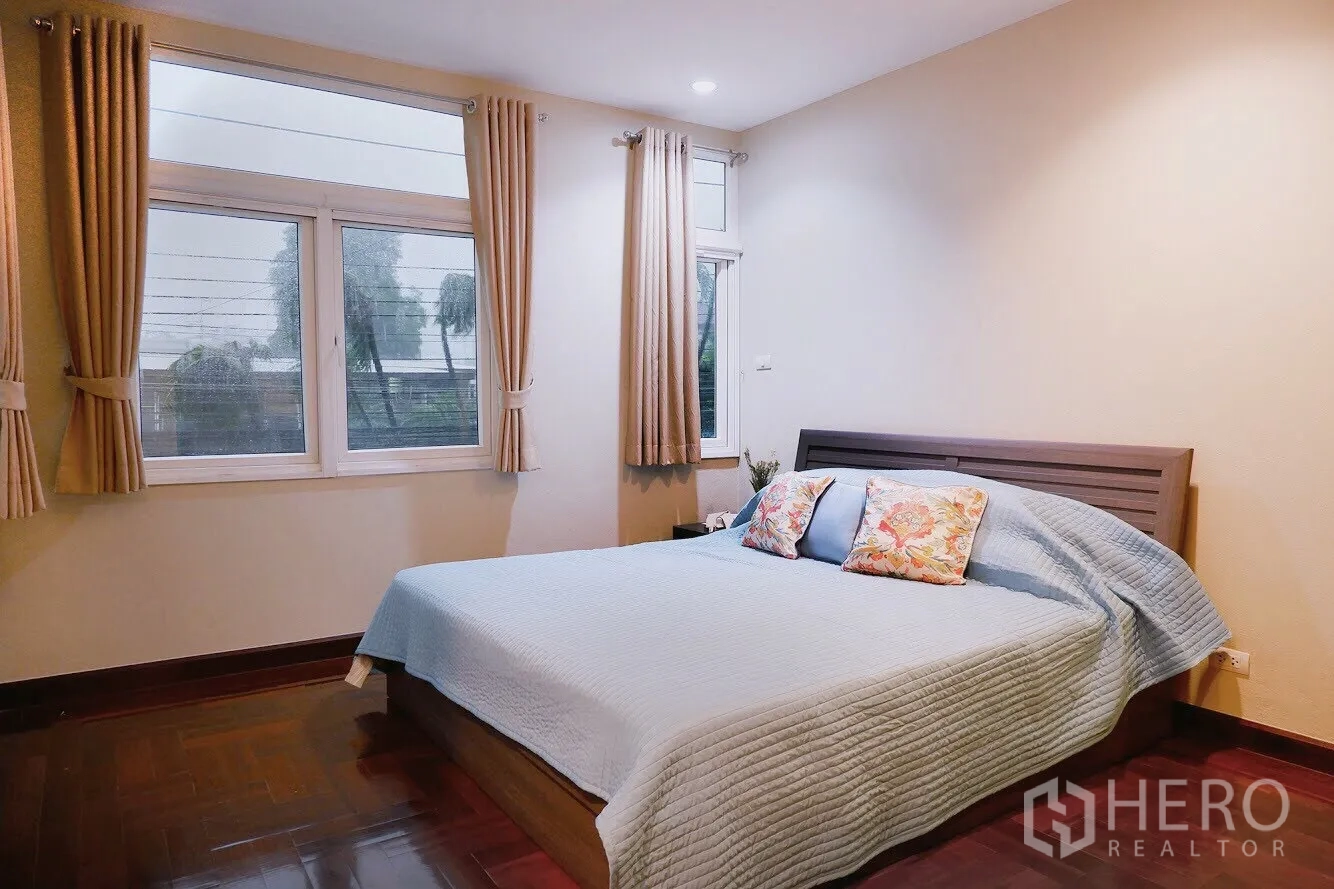 Apartment for rent in Khlong Toei, Bangkok - Corner bedroom with large windows, curtains and queen bed