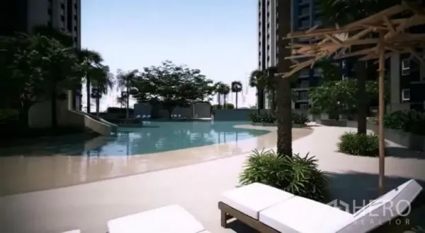 Condominium for sale in Huai Khwang, Bangkok - Resort-style condominium swimming pool with sun loungers, palm trees, and shaded deck