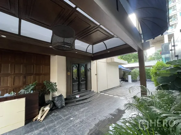 Detached House for rent - Covered entrance porch with dark wood ceiling, double doors and leafy plants.
