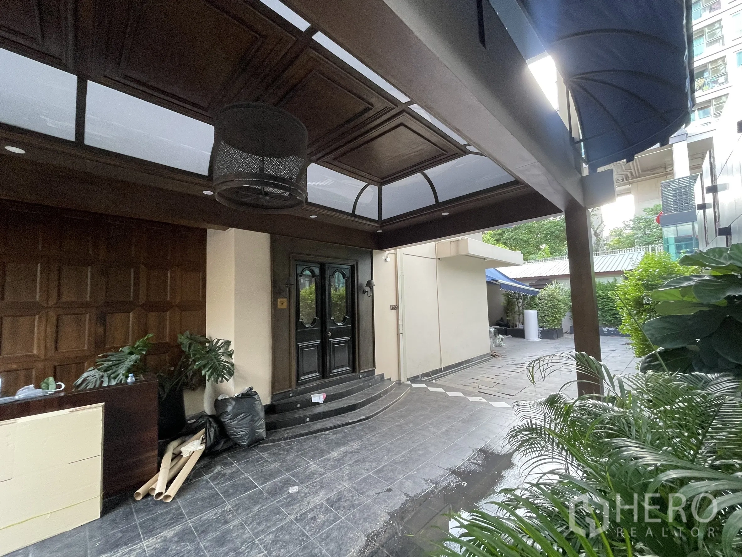 Detached House for rent - Covered entrance porch with dark wood ceiling, double doors and leafy plants.