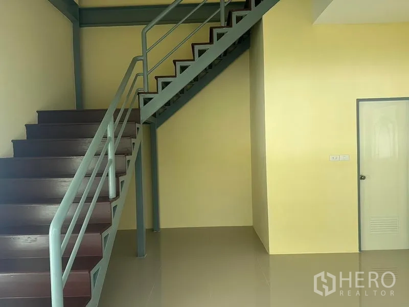 Warehouse for rent or sale in Bang Phli, Samut Prakan - Internal staircase with metal railing leading to the office level beside the storage area.