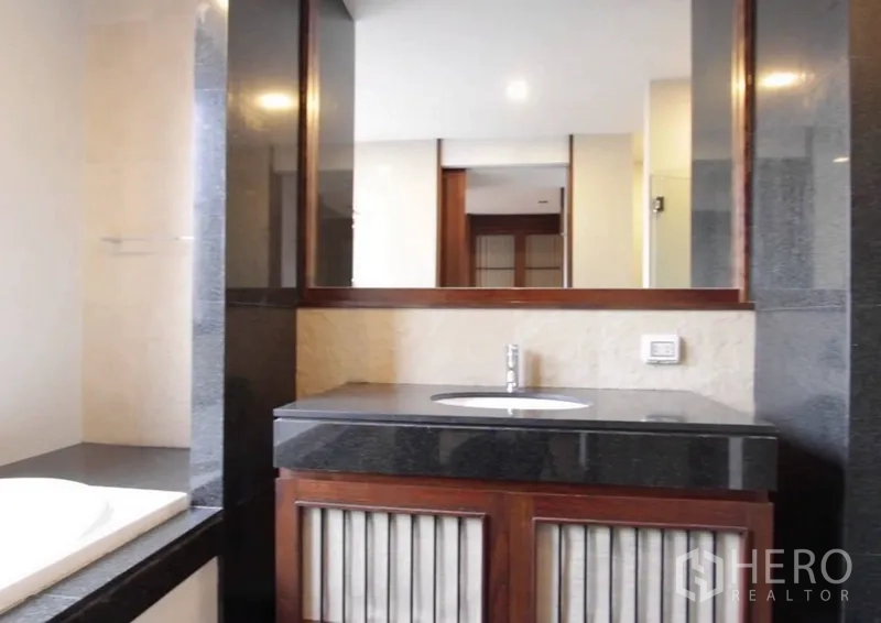 บ้าน ให้เช่าในKhlong Toei, Bangkok - ห้องน้ำสไตล์โมเดิร์น กระจกบานใหญ่ ท็อปหินสีเข้ม และตู้ลิ้นชักไม้