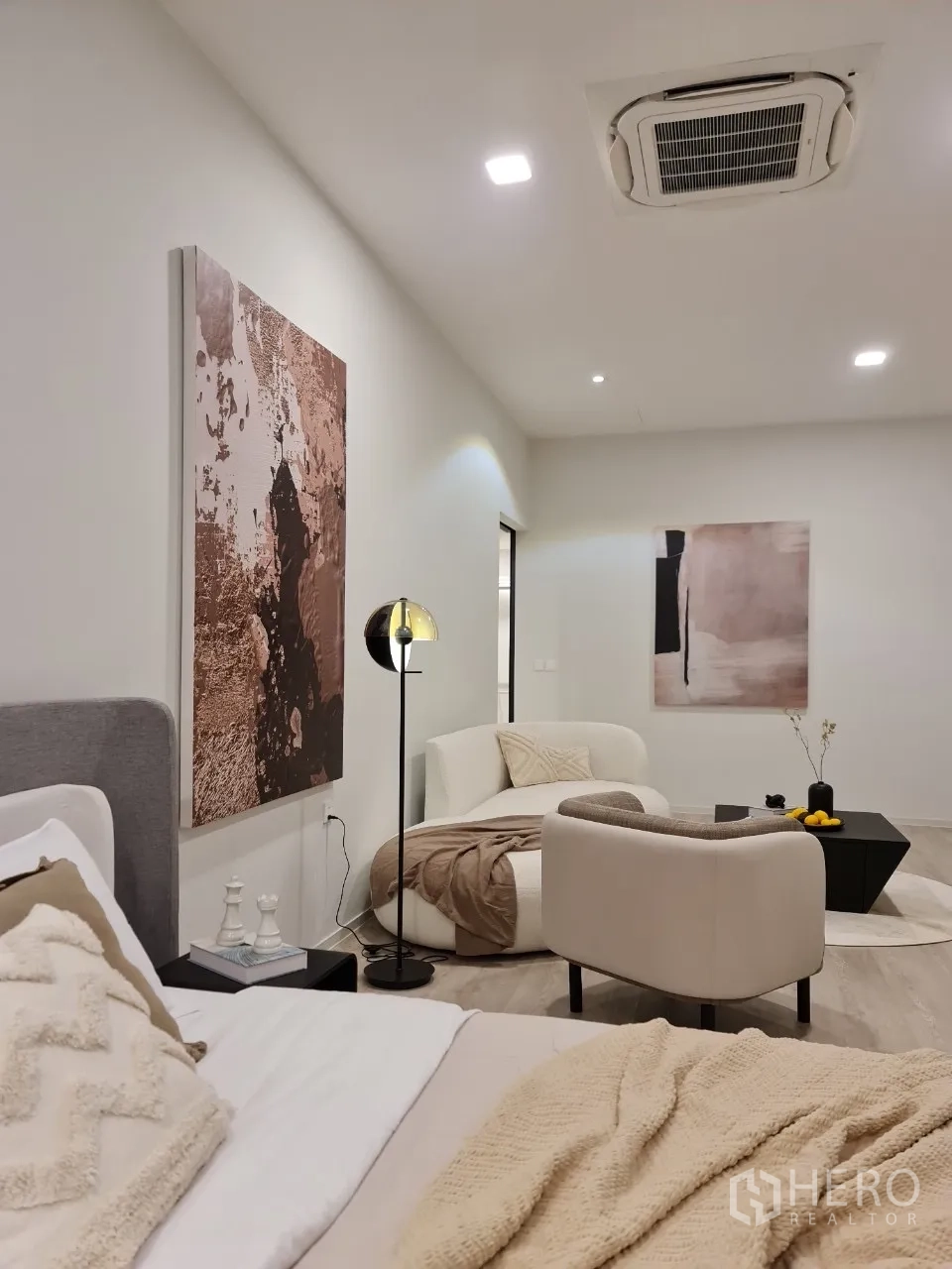 独立式住宅 出租在Saphan Sung, Bangkok - 套间床侧视角，舒适会客区与墙面艺术。