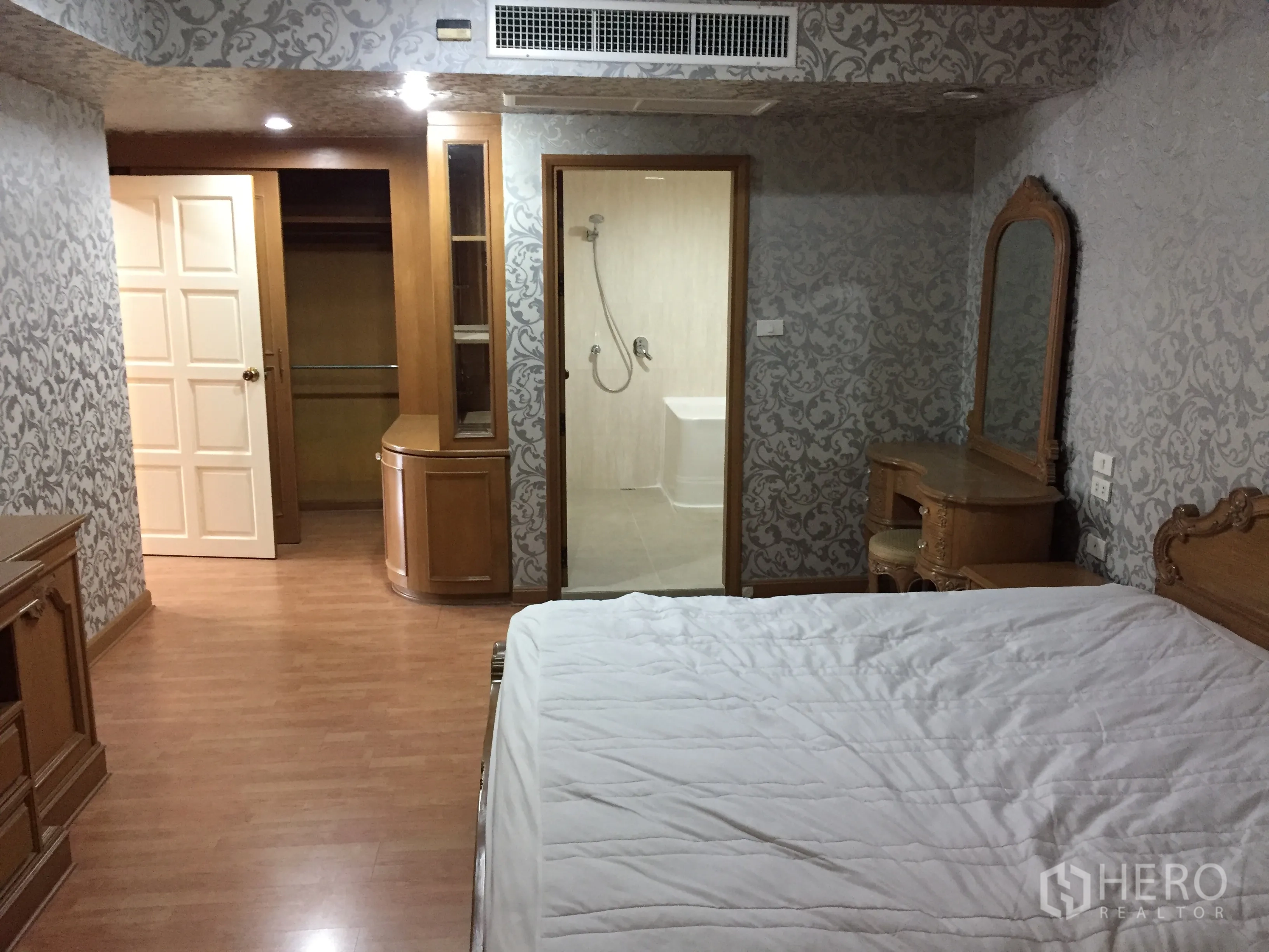 Condominium for rent in Watthana, Bangkok - Master suite view to walk-in closet and en-suite bathroom, with vanity and classic wood built-ins.