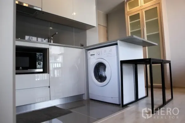 公寓 出租在Watthana, Bangkok - 小厨房内嵌微波炉与前置洗衣机，收纳充足