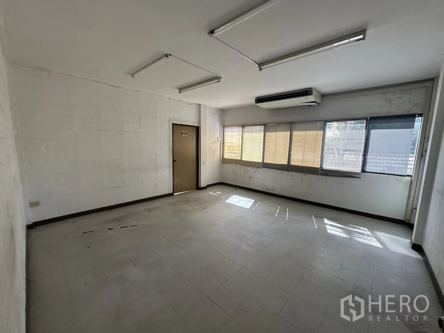 Warehouse for rent in Bang Na, Bangkok - Air-conditioned office with long windows and door to corridor.