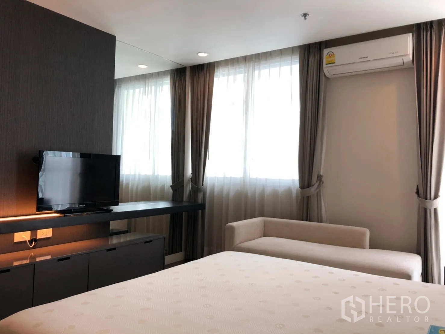 คอนโด ให้เช่าในPathum Wan, Bangkok - ผนังสื่อบันเทิงในมาสเตอร์เบดรูม พร้อมชั้นวางทีวี ชั้นยาว โซฟาเบาะ และหน้าต่างติดผ้าม่าน