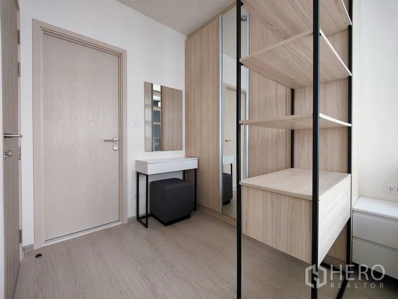 Condominium for rent - Dressing area featuring built-in shelves, mirrored wardrobe and a small vanity table.