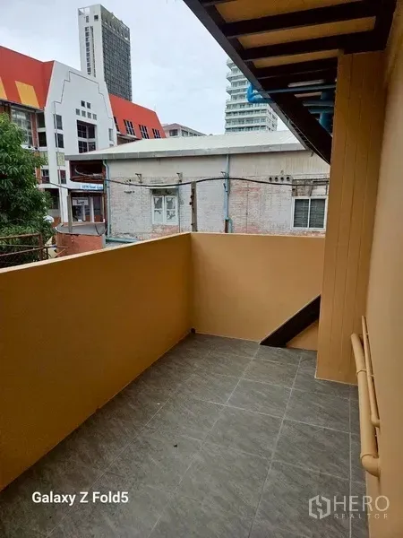 พื้นที่ขายปลีก ให้เช่า - ระเบียงส่วนตัวปูกระเบื้อง พร้อมกำแพงเตี้ยและวิวอาคารโดยรอบ