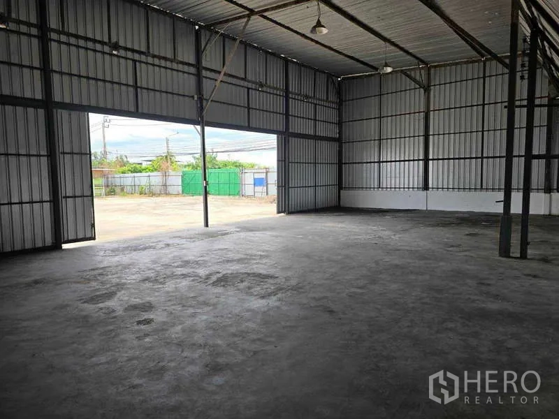 Warehouse for rent in Khlong Sam Wa, Bangkok - Warehouse interior with tall rolling doors opening to the loading yard.