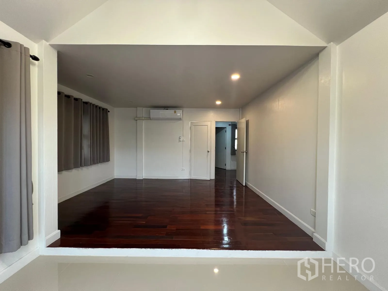 Detached House for rent in Saphan Sung, Bangkok - Spacious room with raised polished hardwood floor, white walls, recessed lights and air conditioning.