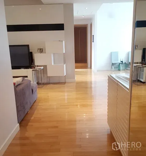 คอนโด ให้เช่าในKhlong Toei, Bangkok - ห้องนั่งเล่นโปร่งสว่าง พื้นไม้โทนอุ่น พร้อมชั้นวางทีวีและโถงทางเดิน