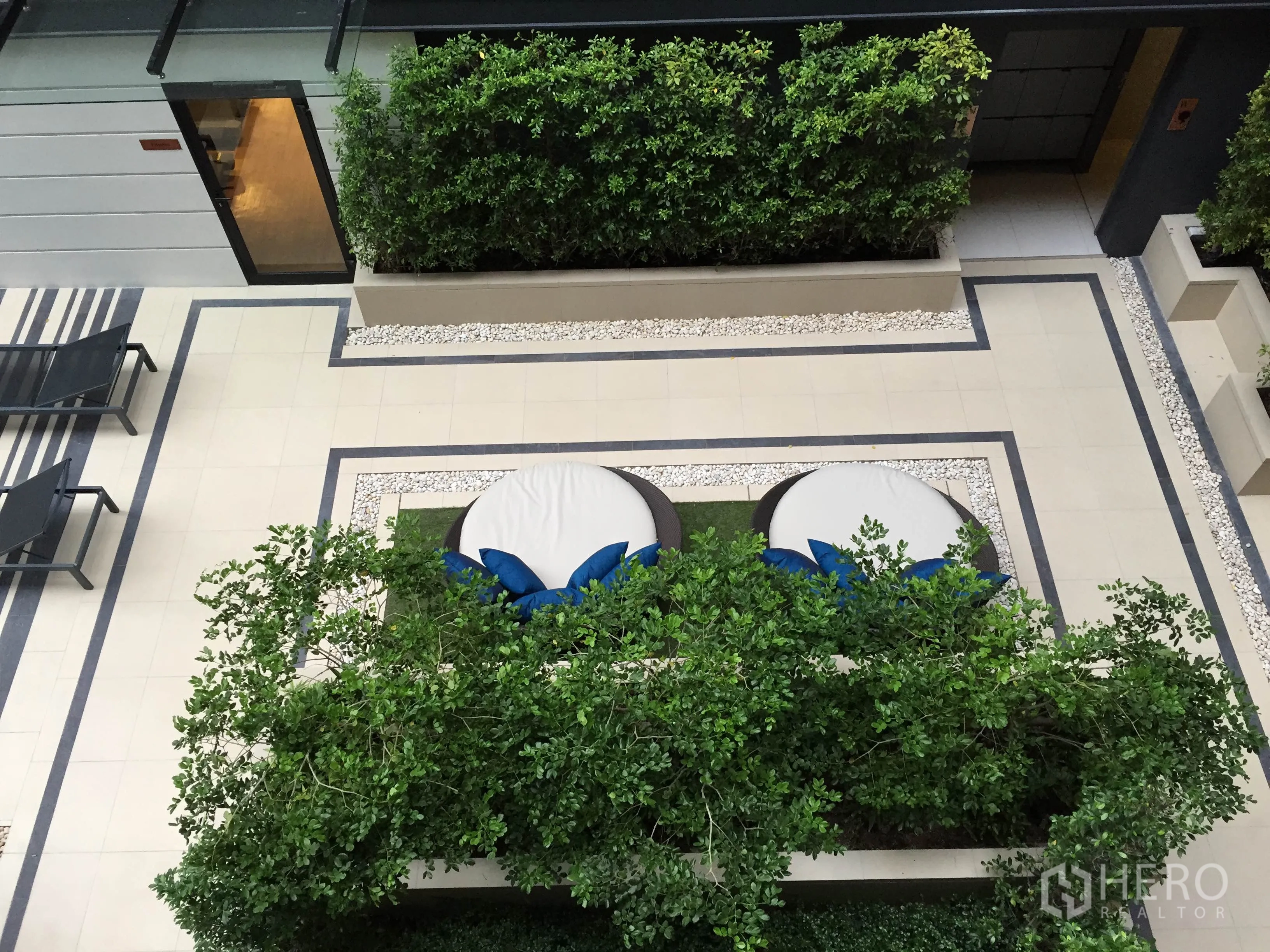 Condominium for rent in Pathum Wan, Bangkok - Landscaped courtyard featuring greenery, lounge daybeds and sun chairs.