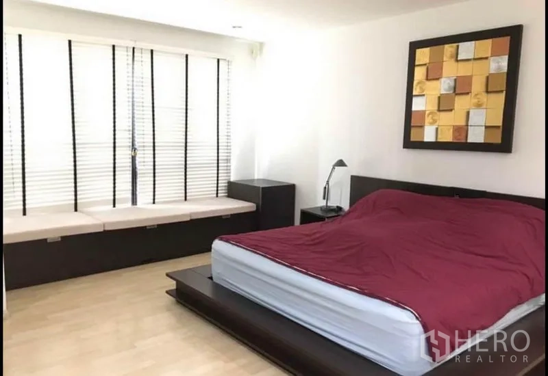 Townhouse for sale in Khlong Toei, Bangkok - Master bedroom with platform bed, bedside tables and long window seat.