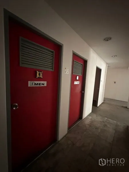 Warehouse for rent in Suan Luang, Bangkok - Interior corridor with prominent red restroom doors and signage.