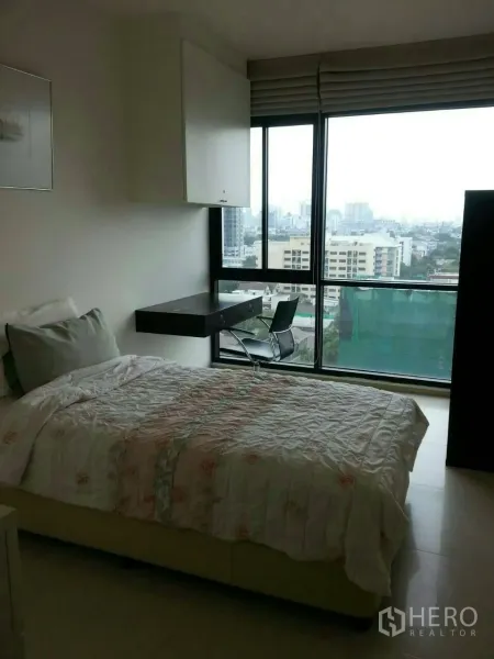 คอนโด ให้เช่าในPhaya Thai, Bangkok - ห้องนอนอบอุ่นพร้อมเตียง โต๊ะทำงานบิลท์อิน และหน้าต่างเต็มบานเห็นวิวเมืองกรุงเทพฯ