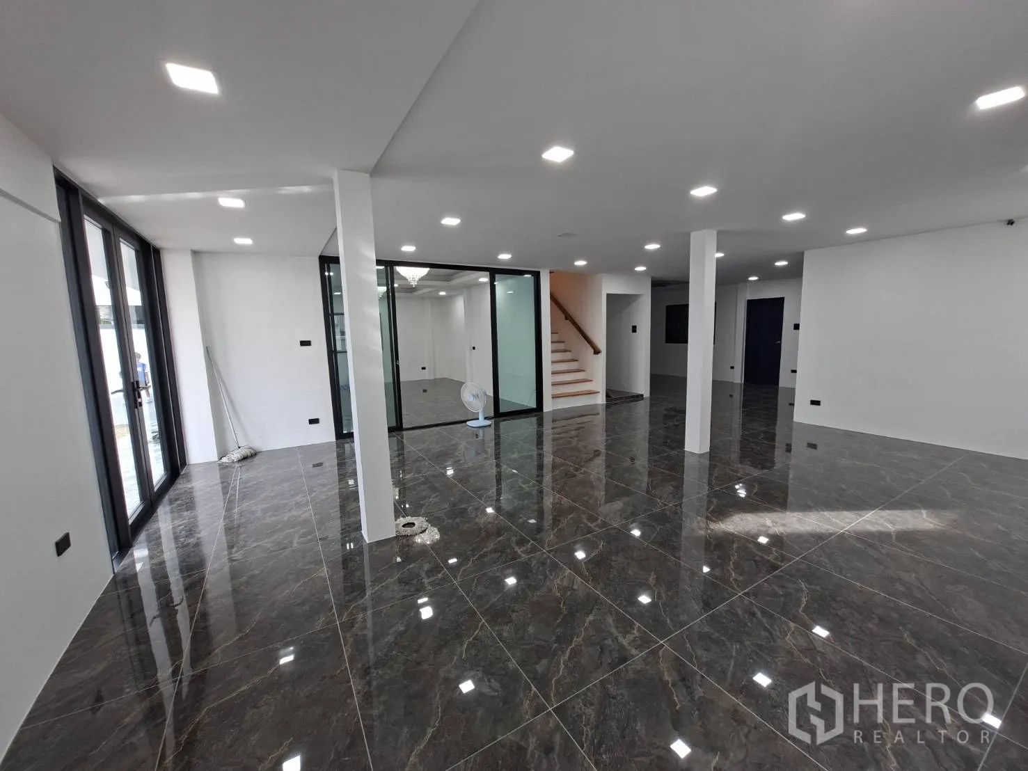 家庭办公室 for rent in Phra Khanong, Bangkok - 一层开放式空间，深色亮面地砖与嵌入式照明。