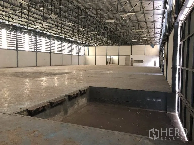 货栈 出租在Khlong Luang, Pathum Thani - 仓库内部宽敞，钢结构高屋顶，混凝土地面，带下沉式装卸坑。