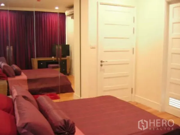 คอนโด ขายในKhlong Toei, Bangkok - ห้องนอนใหญ่ ชุดผ้าปูสีม่วง ตู้เสื้อผ้าบานกระจก พื้นไม้ และประตูบานสีขาว