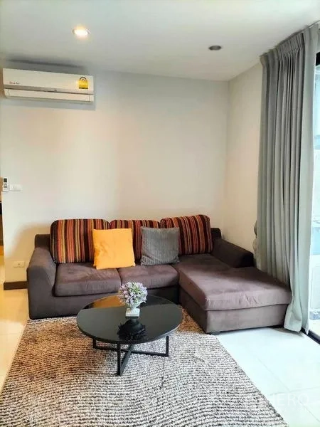 คอนโด ให้เช่าในWatthana, Bangkok - มุมนั่งเล่นมีโซฟาเข้ามุม โต๊ะกลางทรงกลม และพรม