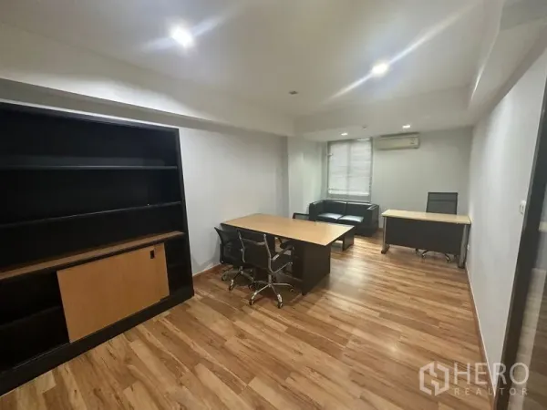 办公空间 出租在Khlong Toei, Bangkok - 独立办公室，配书架、办公桌、黑色沙发和百叶窗，木质地面