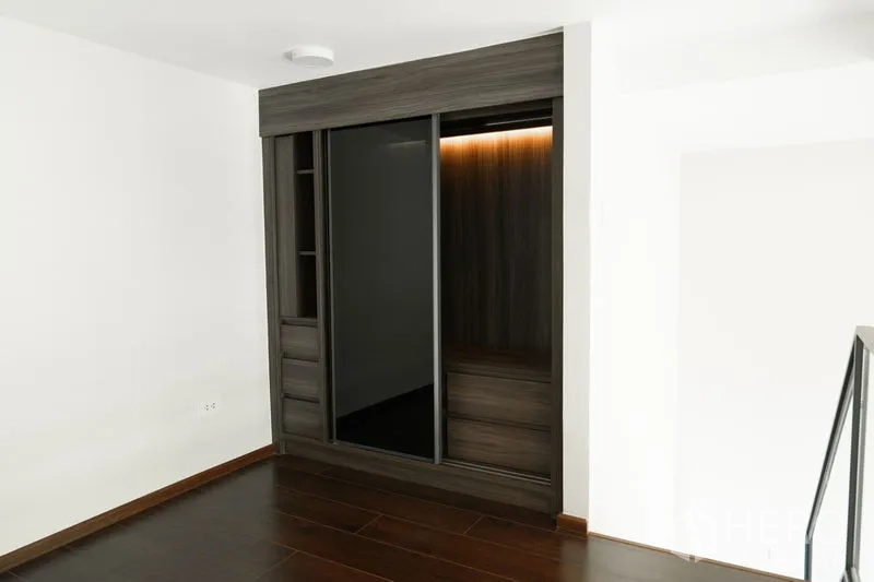 Condominium for sale in Watthana, Bangkok - Built-in sliding-door wardrobe with warm internal lighting on the mezzanine level.
