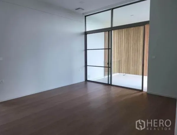 บ้าน ให้เช่าในSaphan Sung, Bangkok - ห้องนั่งเล่นสว่าง พื้นไม้ เพดานสูง และประตูกระจกบานเลื่อนเปิดออกสู่ระเบียง