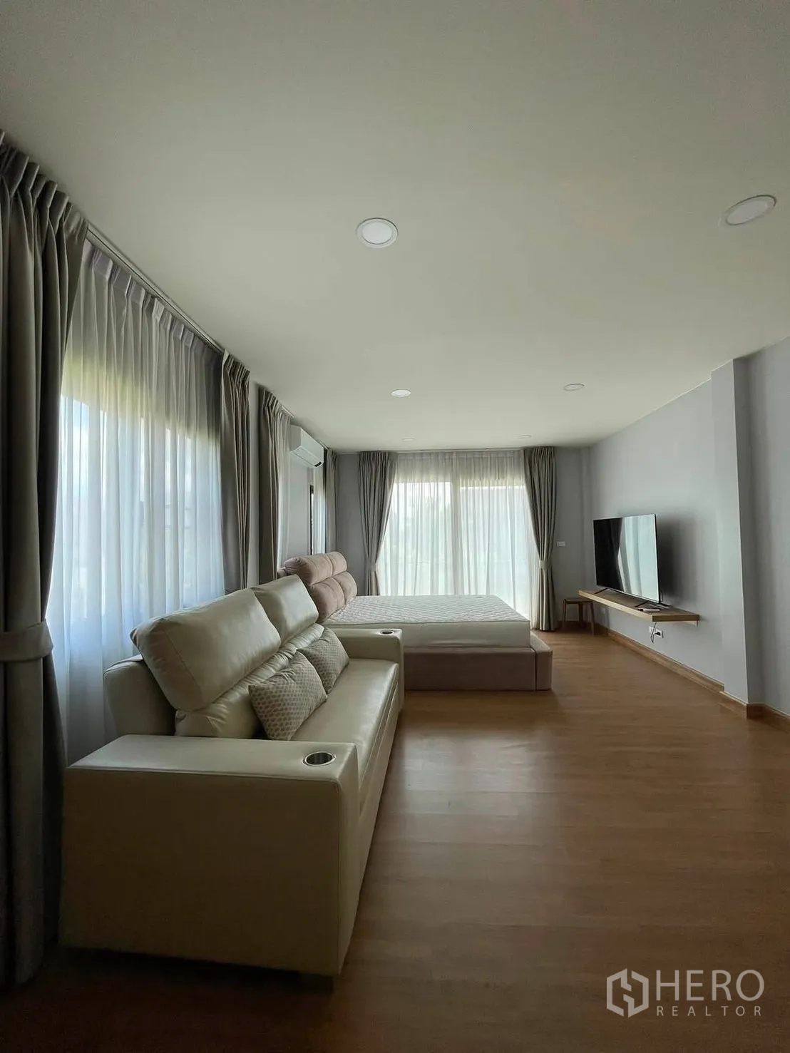 独栋房屋 for rent in Bang Phli, Samut Prakan - 宽敞主卧带沙发、床、电视柜及环绕落地窗帘。