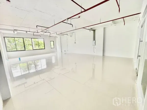 Office Space for rent in Khlong Toei, Bangkok - Bright open-plan 92 sqm office with glossy tile flooring, large windows, and exposed red sprinkler pipes near BTS Ekkamai in Khlong Toei, Bangkok.