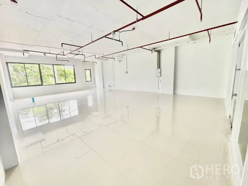Office Space for rent in Khlong Toei, Bangkok - Bright open-plan 92 sqm office with glossy tile flooring, large windows, and exposed red sprinkler pipes near BTS Ekkamai in Khlong Toei, Bangkok.