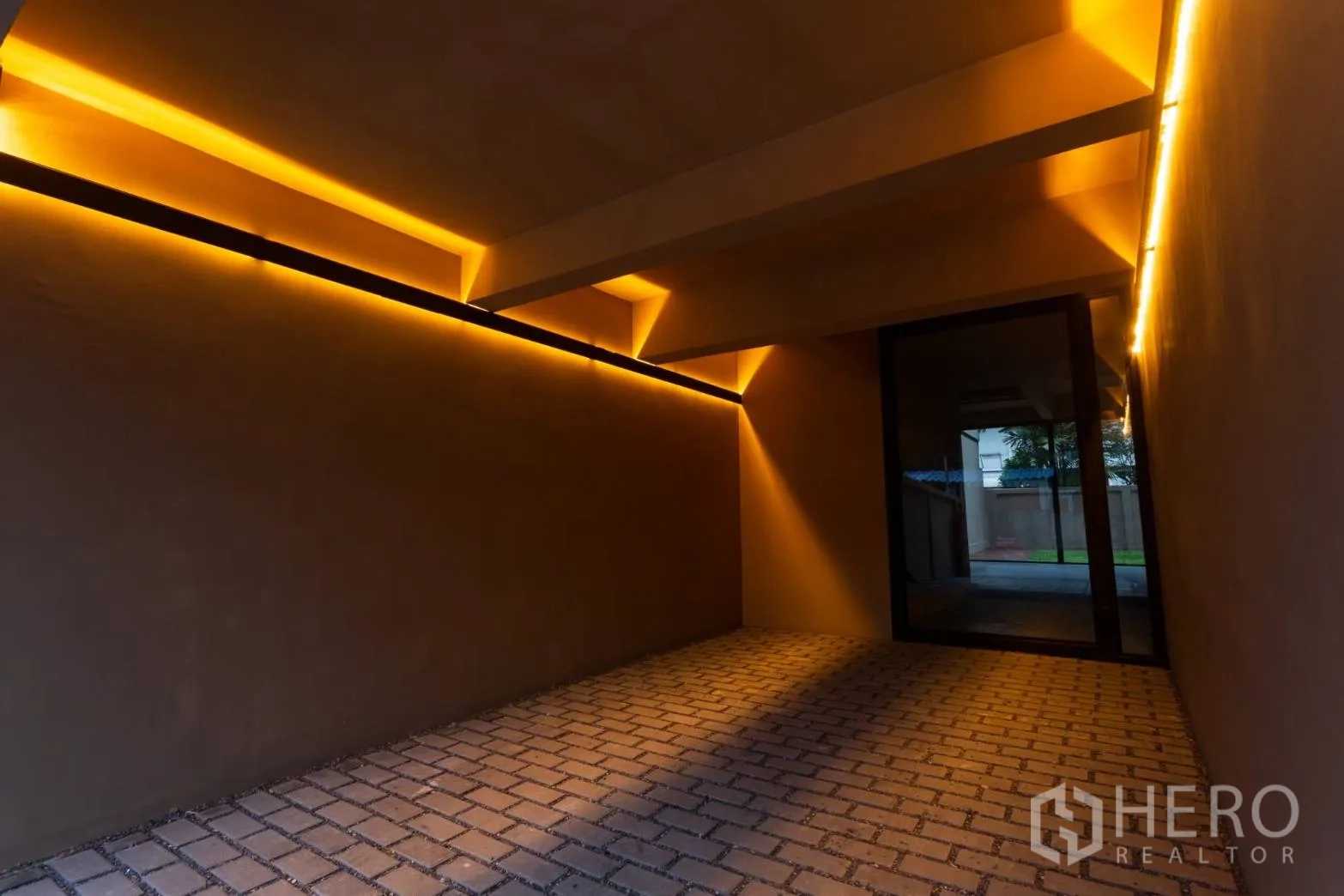 Home Office for rent in Watthana, Bangkok - Covered parking bay with warm architectural lighting at dusk.
