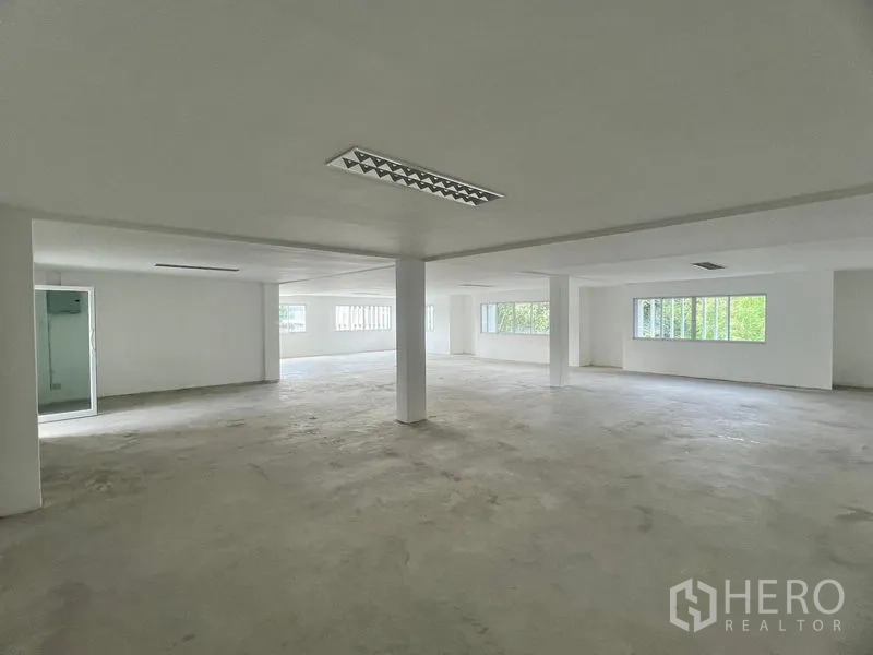 零售空间 出租在Huai Khwang, Bangkok - 开阔零售空间，吊顶荧光灯、玻璃门服务间与多面窗户。