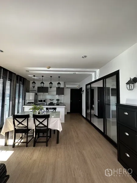 公寓 出租在Khlong Toei, Bangkok - 明亮的开放式餐厨区，设中岛与吊灯，落地窗采光充足。