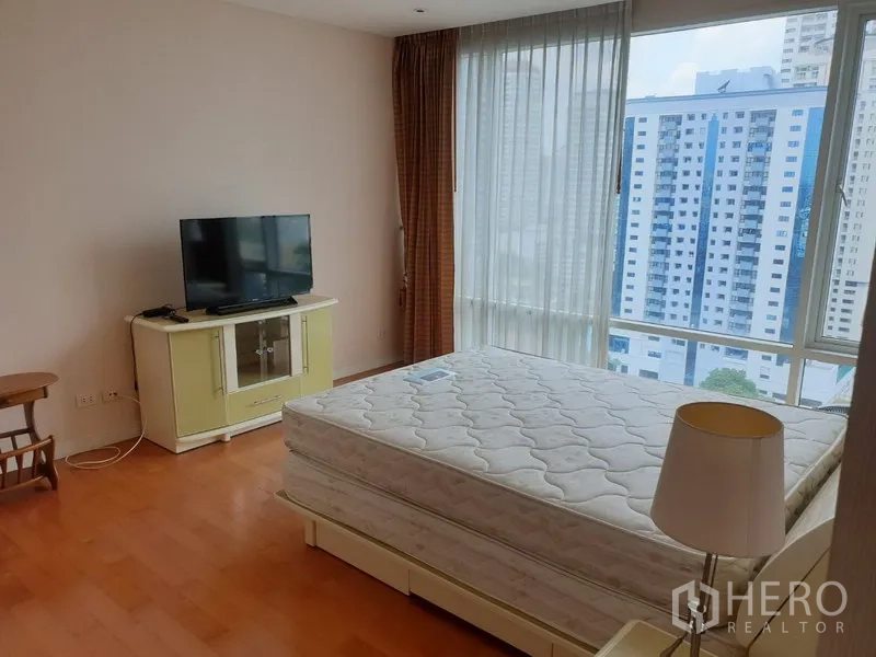 คอนโด ให้เช่าในWatthana, Bangkok - ห้องนอนหลักมีหน้าต่างมุมบานใหญ่ เตียงพร้อมที่นอน ชั้นวางทีวี และพื้นไม้โทนอุ่น