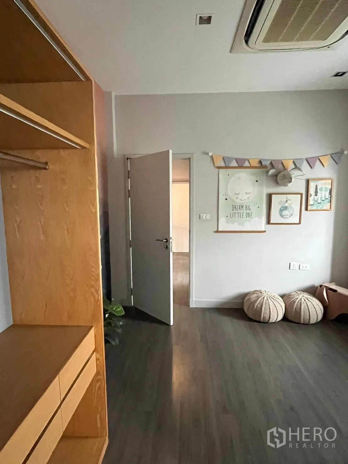 独栋房屋 for rent or sale in Bueng Kum, Bangkok - 卧室一角，开放的房门、墙面装饰、坐墩和木质衣柜。