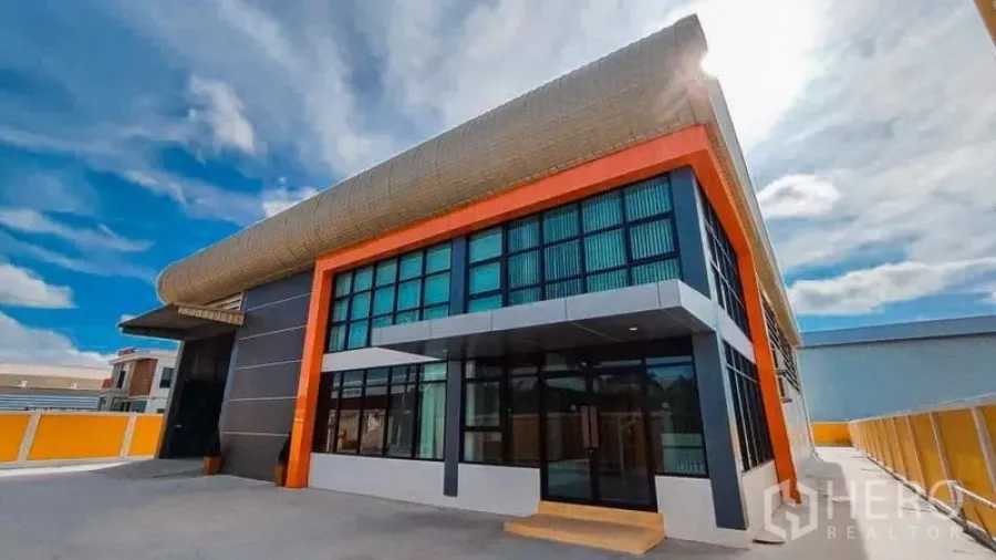 Factory for sale in Bang Pakong, Chachoengsao - Angle view of contemporary factory exterior with gated driveway